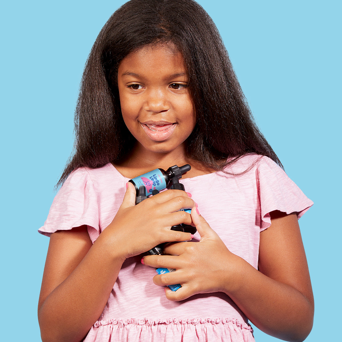 Smiling girl hugging bottles of Lingo Leap